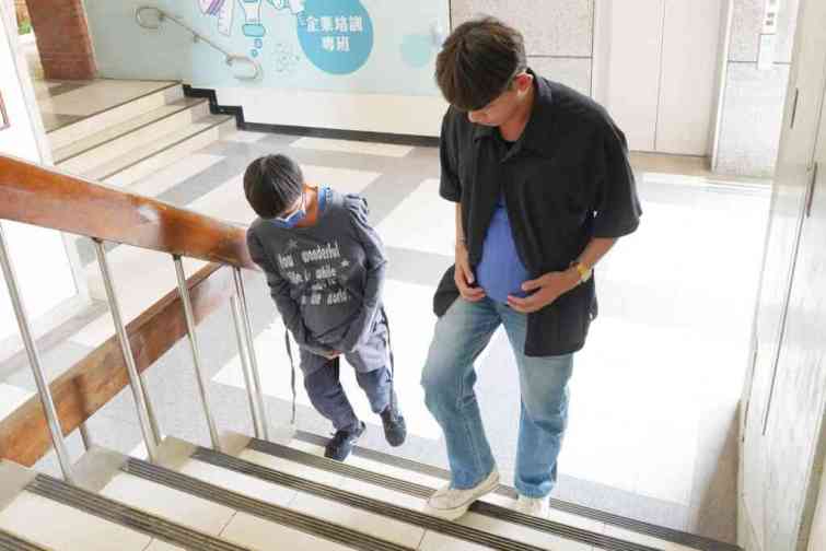 ▲參訪大葉的學生穿上孕婦體驗裝爬樓梯。（大葉大學提供）