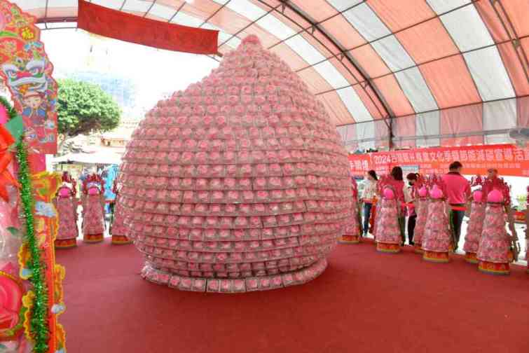 ▲苗栗縣糕餅業者以八千顆小壽桃，打造一個24層巨型壽桃。（苗栗縣政府提供）