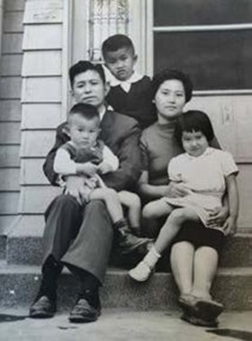 作者父母抱著其三弟、妹妹和大弟 ( 後 ),坐在穿堂前的階梯上合影。當日作者應該是去上學了,沒趕上這次家人合影。圖/沈春池文教基金會提供