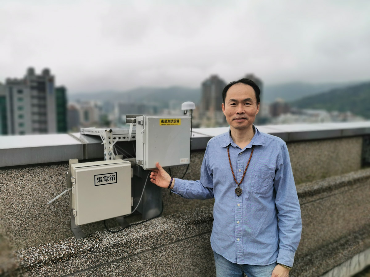 康晤總經理陳明宗(Alvin)與其位於大樓頂層的設備合影。