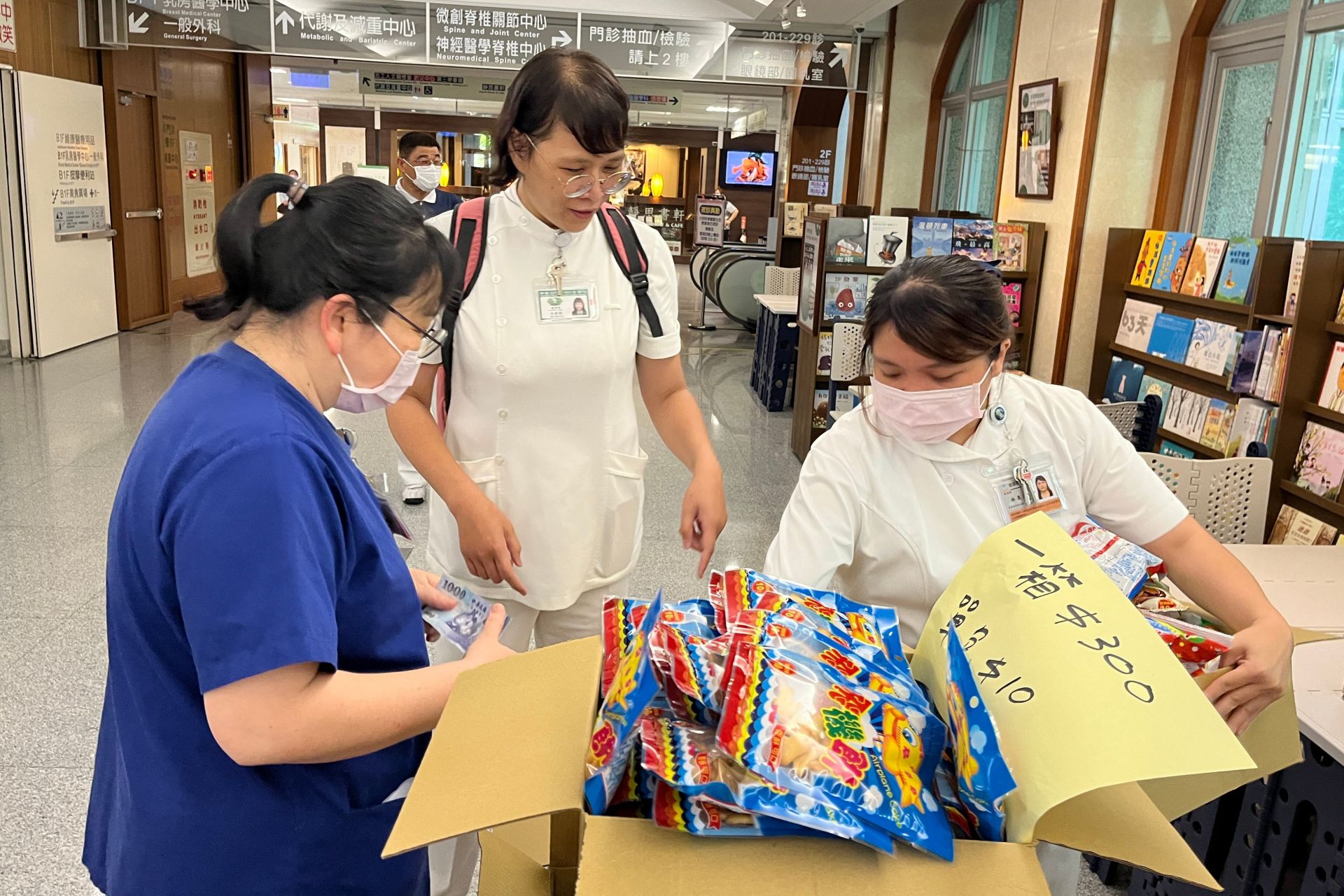 心蓮病房安寧共照護理師林惠涓(右)的父親,感恩生病時受台中慈院照顧,捐出卅箱餅乾義賣,形成善的循環。