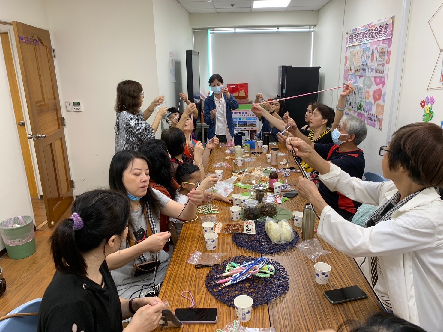 余欣洳教新住民動手編織手機腕繩。(記者張欽翻攝)