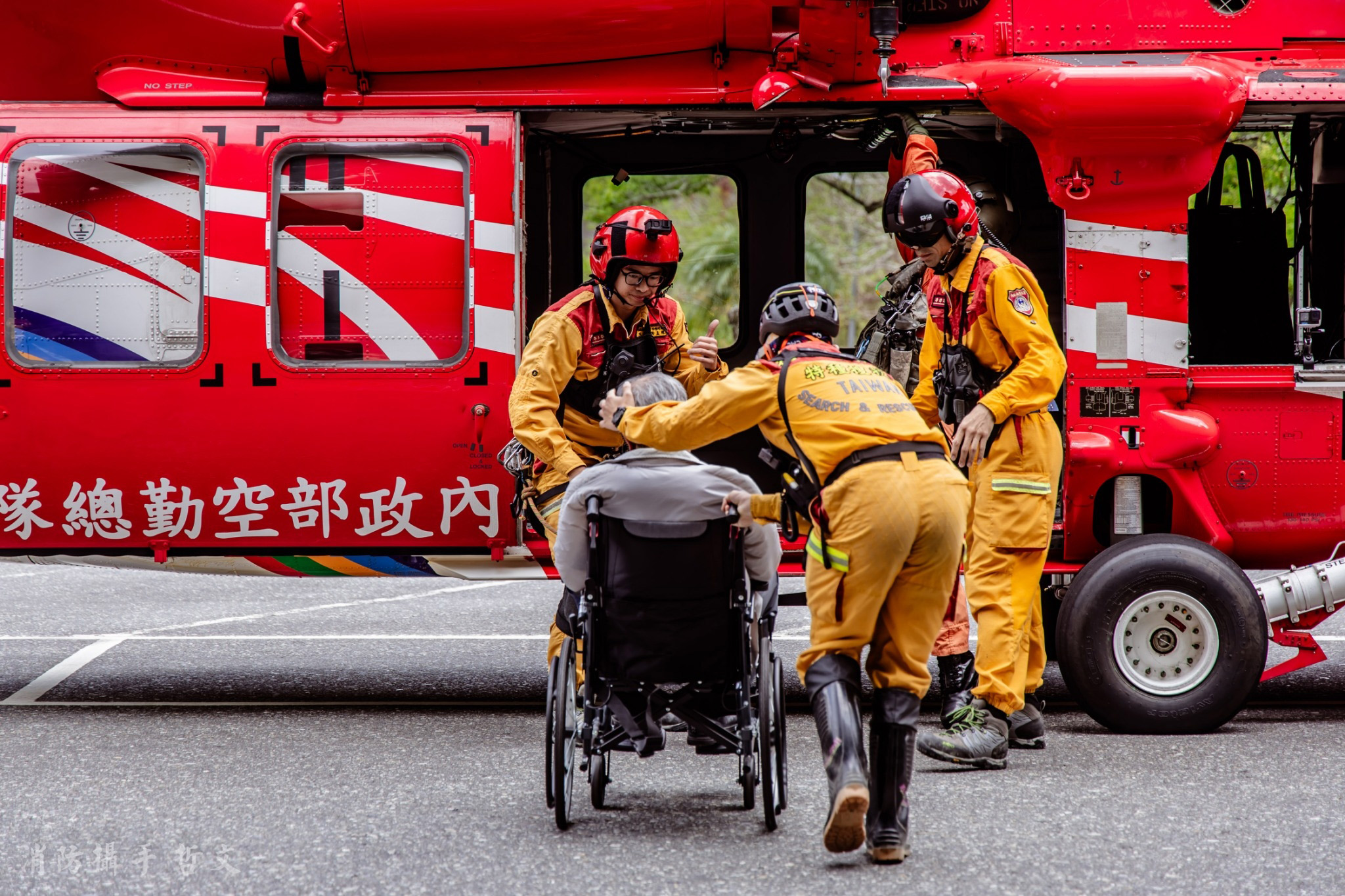 搜救隊員向坐輪椅的脫困民眾比讚手勢,代表對受困民眾表達平安的祝福。