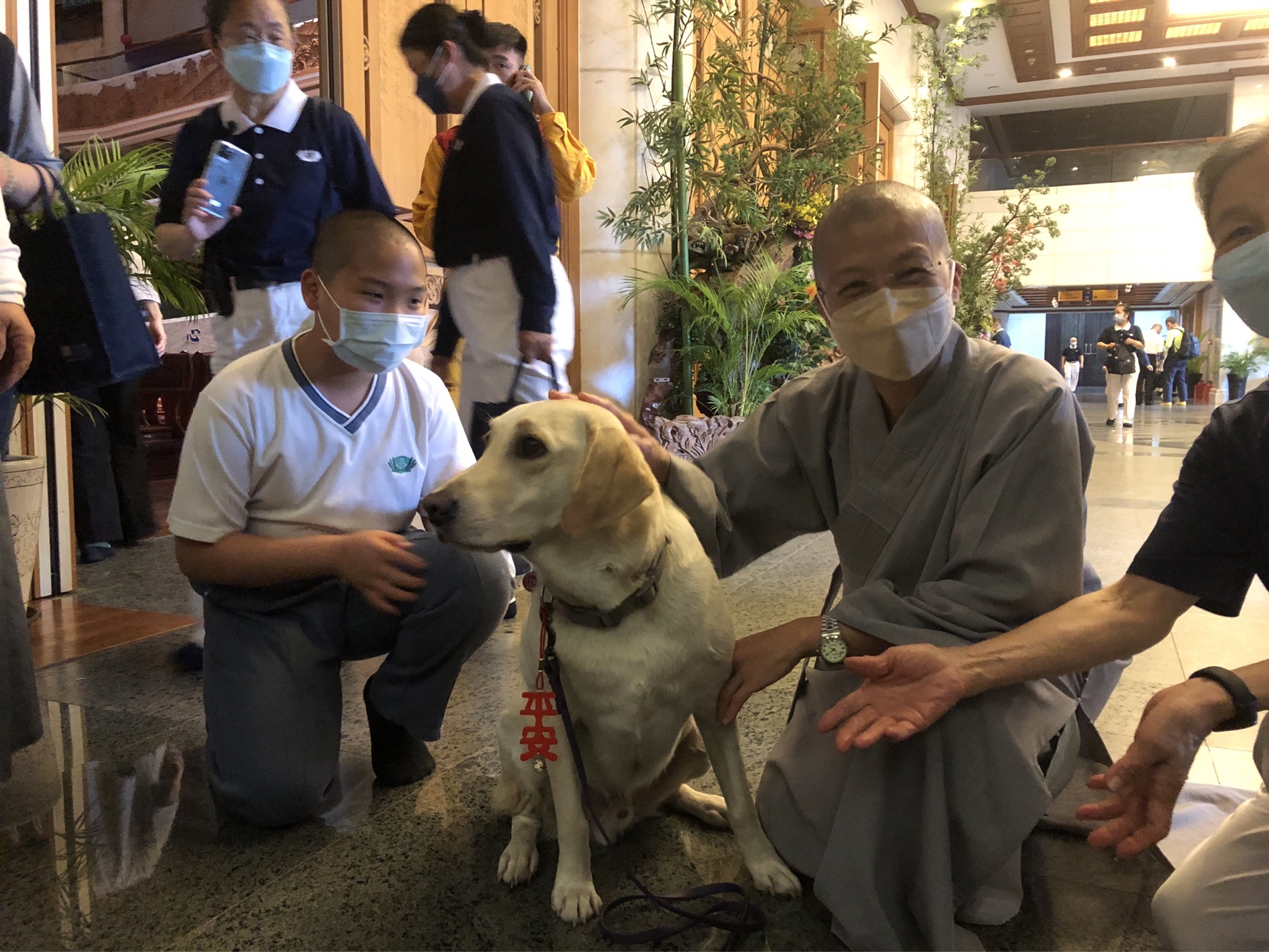 出席在花蓮靜思堂舉辦安心祈福會的花蓮縣消防局搜救犬Hero,獲靜思精舍法師贈予「平安」吊飾。