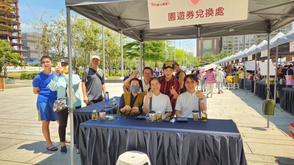 在現場遊園券攤位中,慈濟靜思書軒職工陳淑女和同仁還有好朋友合影畫面。(圖/陳惠玲攝)