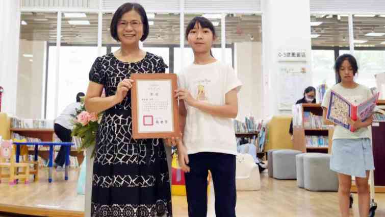 ▲彰化市立圖書館館長李逢時頒發參展忠孝國小美術班同學獎狀。（記者林明佑攝）