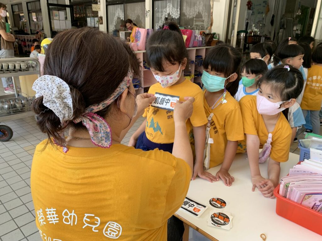 參與飢餓體驗的孩子們一同貼上「飢餓中」貼紙，挑戰12小時不進食。_