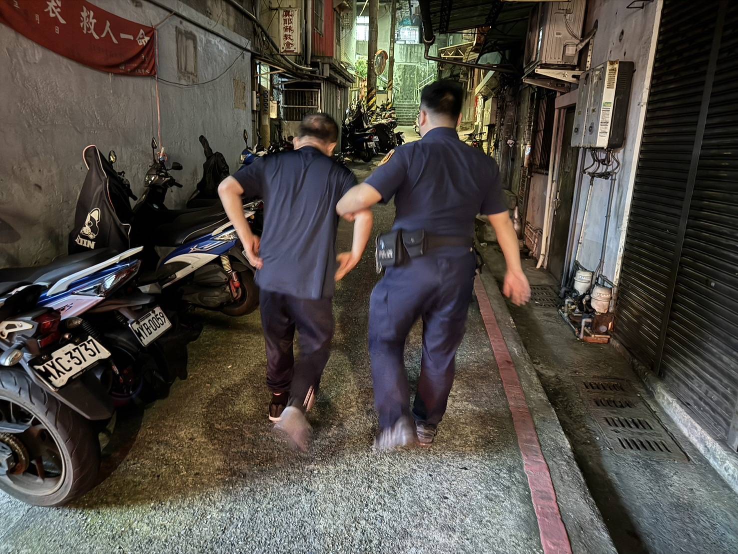 警方攙扶吳民返家。（記者薛秀蓮翻攝)