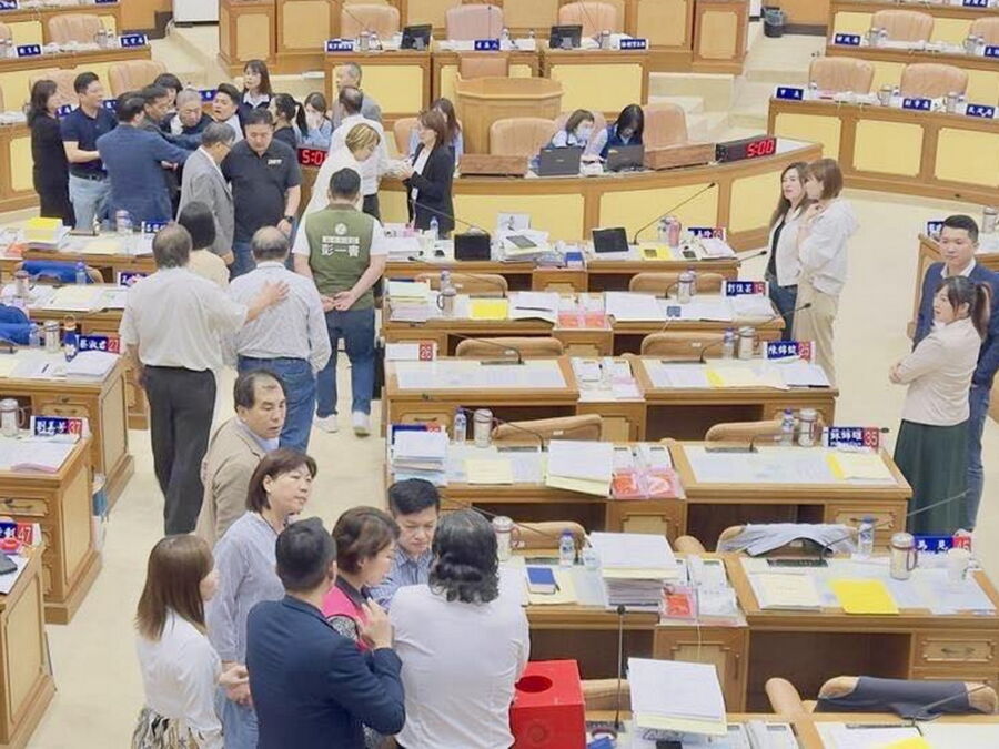 圖/國民黨籍議長蔣根煌氣得當場丟手機並爆五字經粗口,一度衝下主席台要找陳明義理論,多名藍綠議員則上前安撫。(翻攝新北市議員李宇翔臉書)