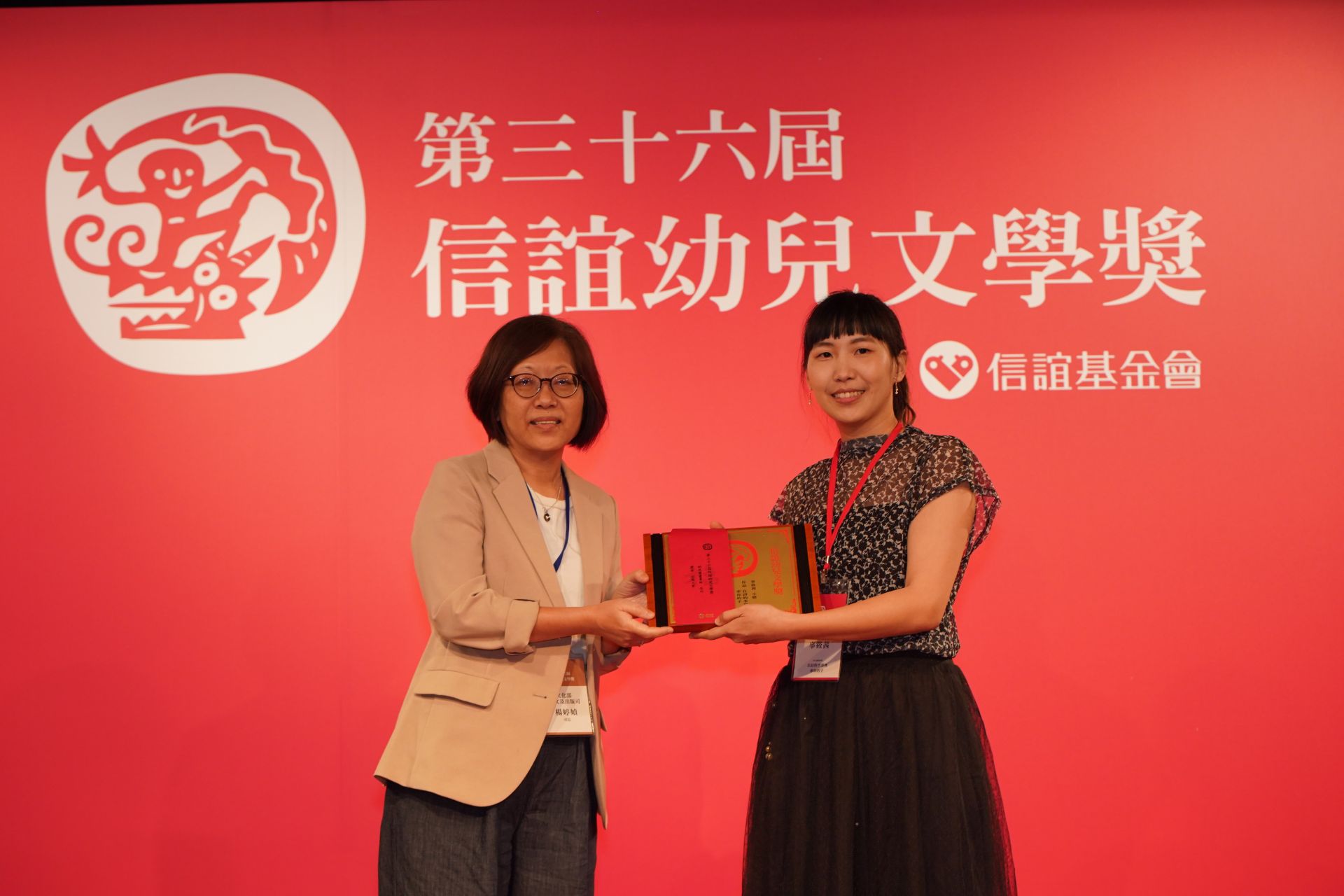 文化部人文及出版司司長楊婷媜(左)頒發信誼幼兒文學獎幼兒圖畫書組佳作獎,幼兒園教師辜筱茜領獎