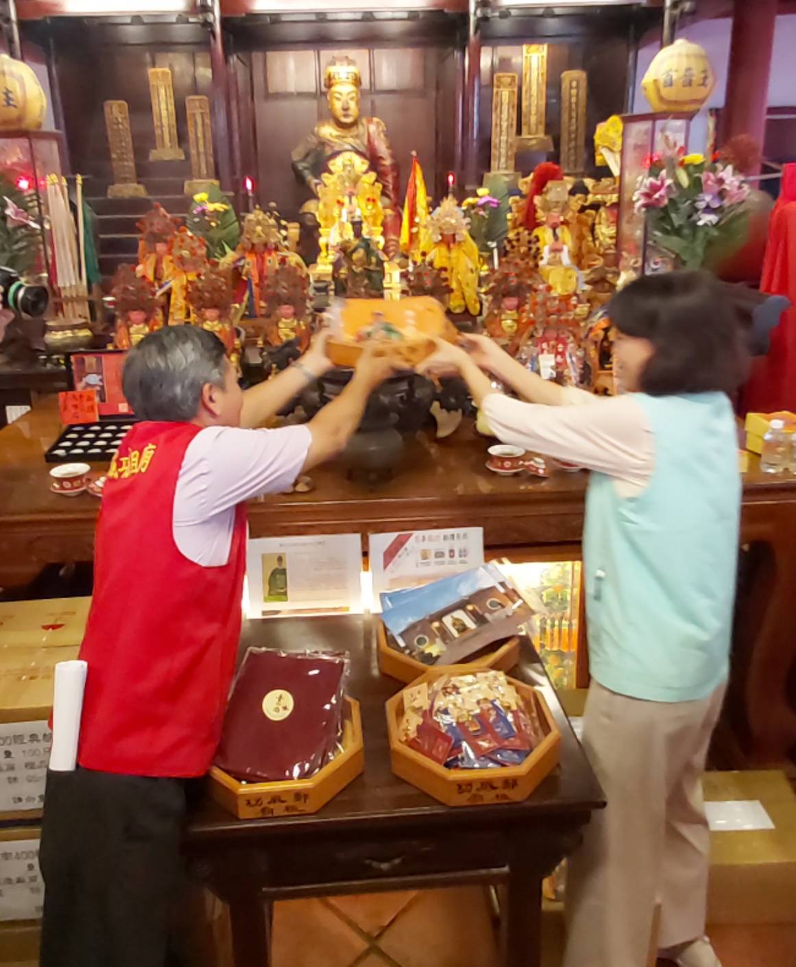 ▲鄭成功祖廟主委鄭有懋（左）、台南郵局副局長游素珍（右）一同將限量福袋過爐加持。（圖／記者陳彥霖攝）