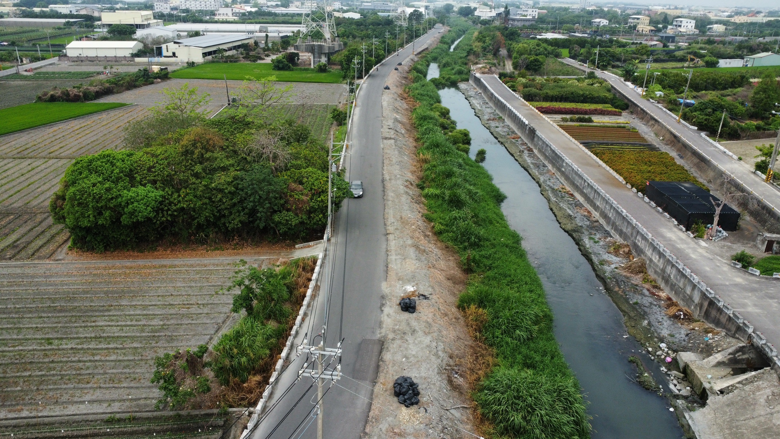 ▲北斗鎮清水溪堤岸經常被民眾「摸黑」亂丟垃圾，北斗鎮大道里里長許明圖在沿岸樹木貼上「請勿在此丟垃圾，除非家有喪事」告示奏效。（記者張溎壕攝）