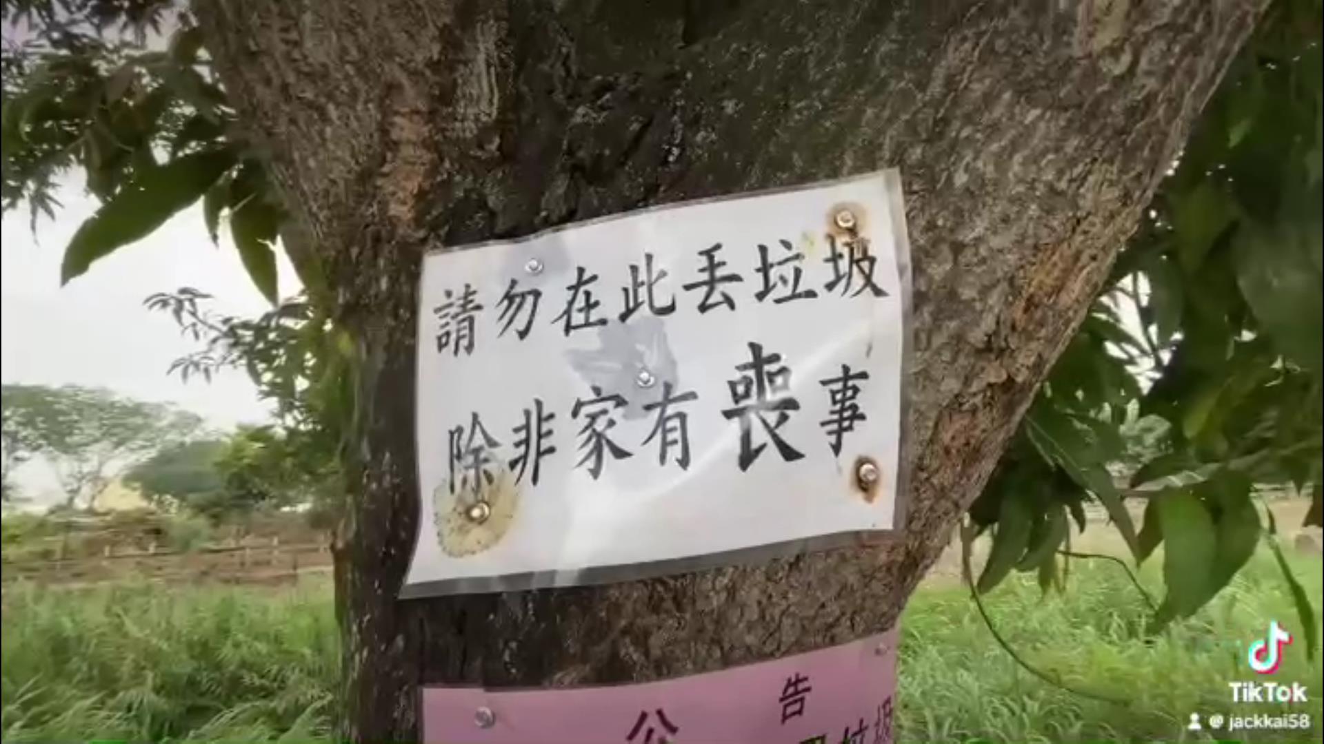 ▲北斗鎮清水溪堤岸經常被民眾「摸黑」亂丟垃圾，北斗鎮大道里里長許明圖在沿岸樹木貼上「請勿在此丟垃圾，除非家有喪事」告示奏效。（記者張溎壕攝）