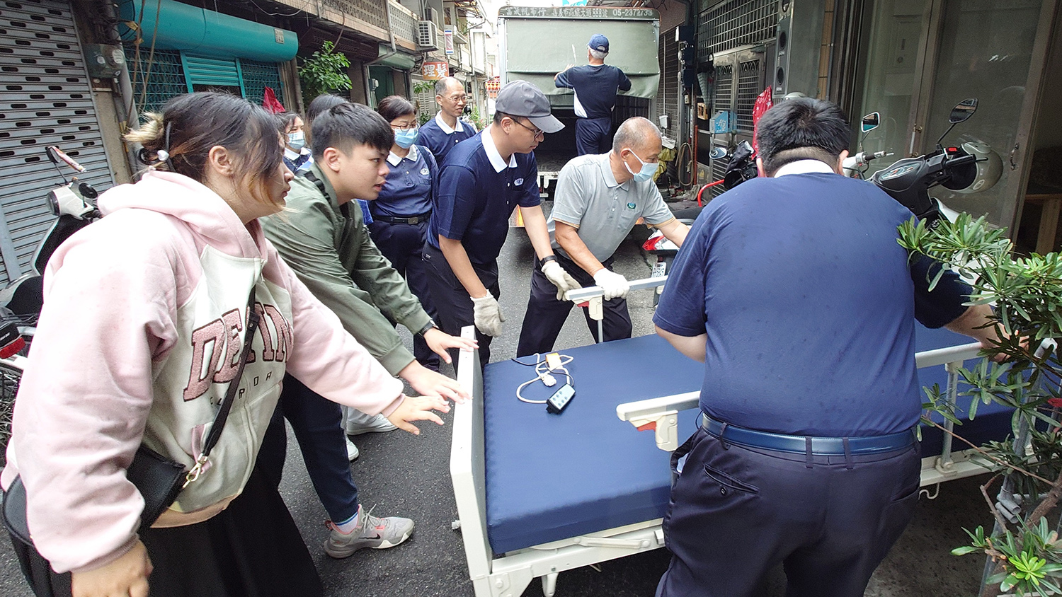 (上)熱血年輕人,利用假日和志工運送電動醫療床到案家,給予案家溫暖的關懷。