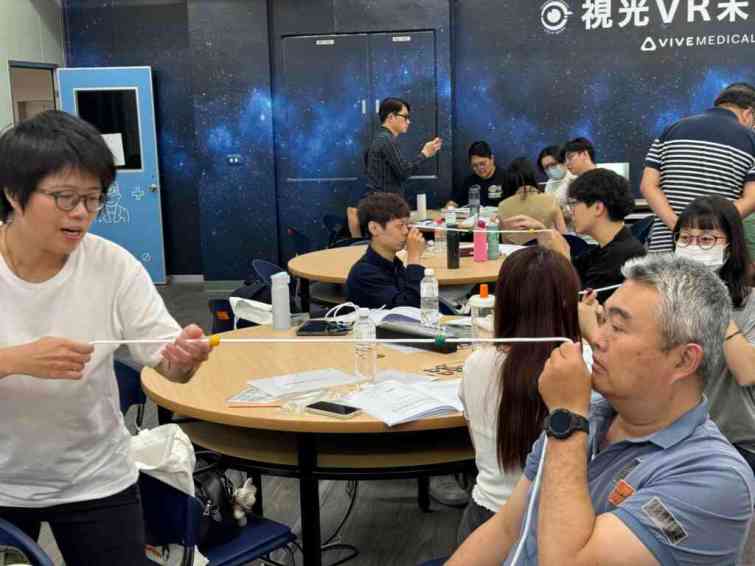 ▲大葉大學視光學系陳雅郁老師(左)教學員使用聚散球訓練眼睛運動能力。（大葉大學提供）