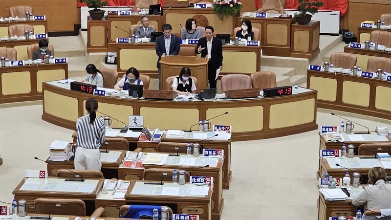 國民黨新北市議員江怡臻（前背對者）29日在議會質詢時詢及副總統賴清德萬里老家用地爭議。中央社