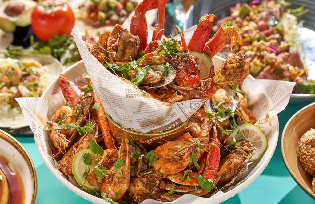 嚴選松葉蟹腿、螃蟹、蝦、鮑魚、青口貝、中卷等海鮮食材,與特製的濃郁辛香料醬汁充分攪拌,辛辣又豪邁的一人獨享海鮮桶新鮮登場!(台北福華大飯店提供)