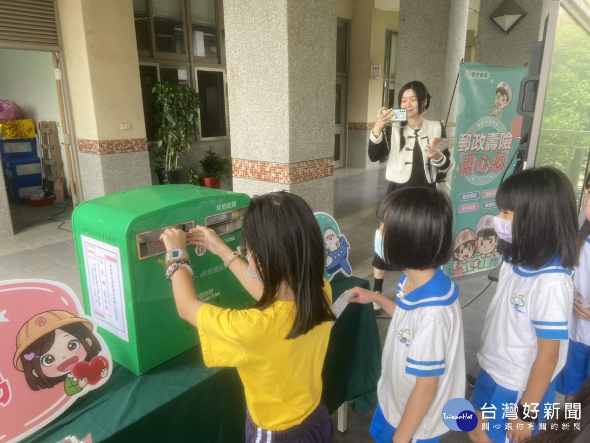 同學們拿著明信片投入郵筒交寄
