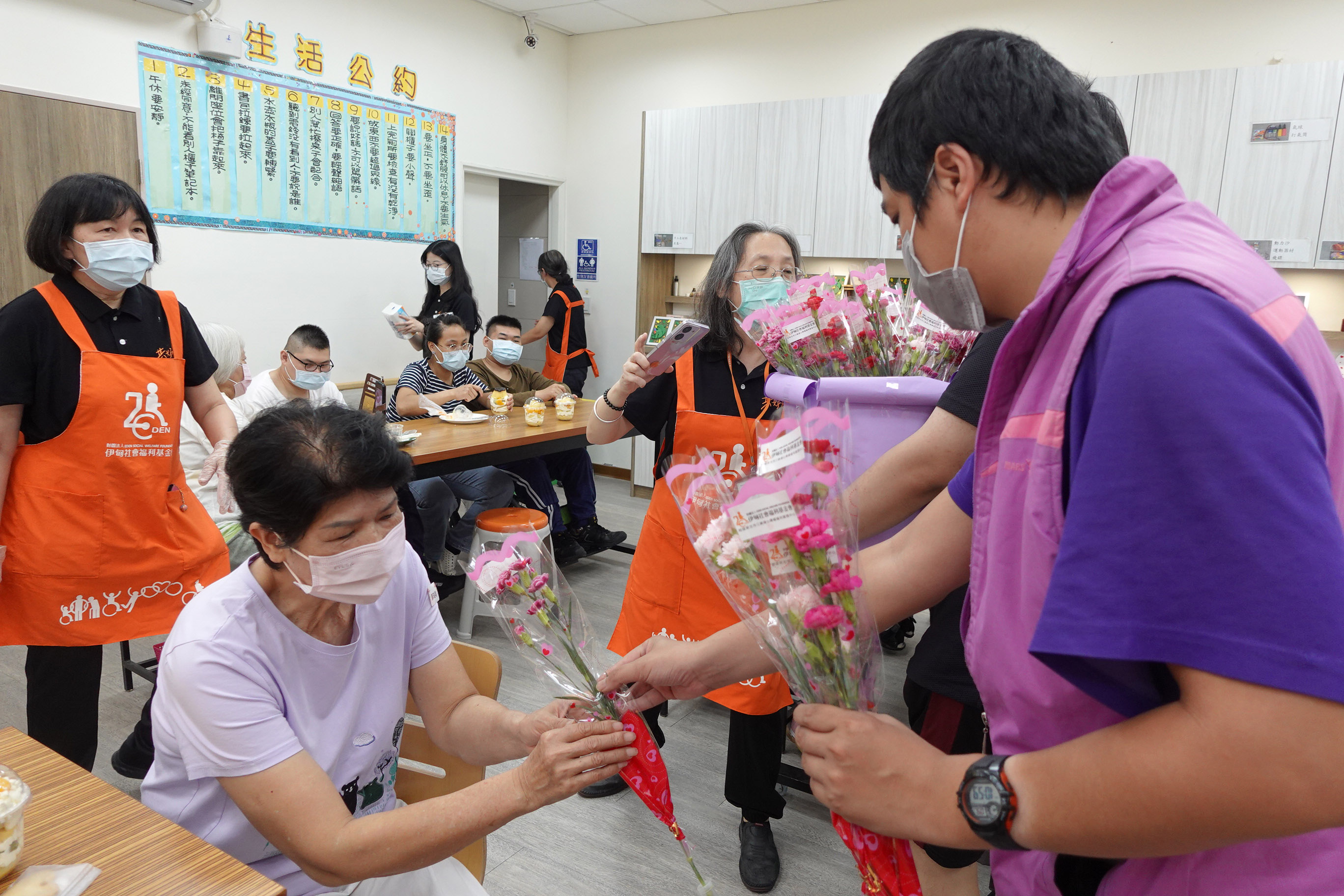 伊甸三峽國光日照中心的阿翔,為據點長輩們獻上康乃馨,提前祝他們母親節快樂