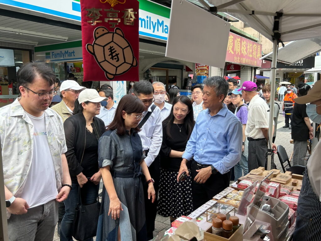 洪文合理事長帶隊介紹大口吃萬華現場攤位