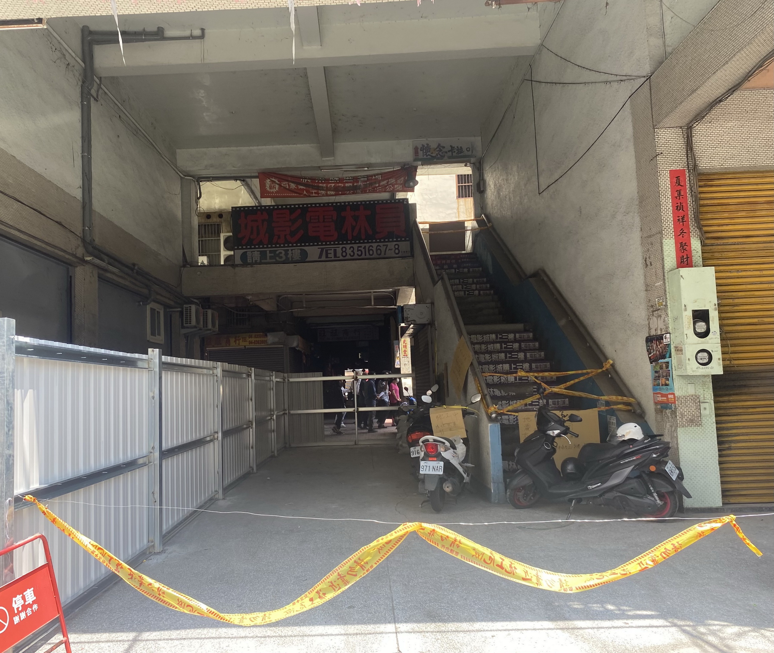 ▲員林市綜合市場大樓南側（光明街）通道，從上月起突然被架起大片鐵皮圍籬，造成大樓內住戶、攤商等使用民眾難以進出，市場攤商拉白布條抗議。（記者張溎壕攝）