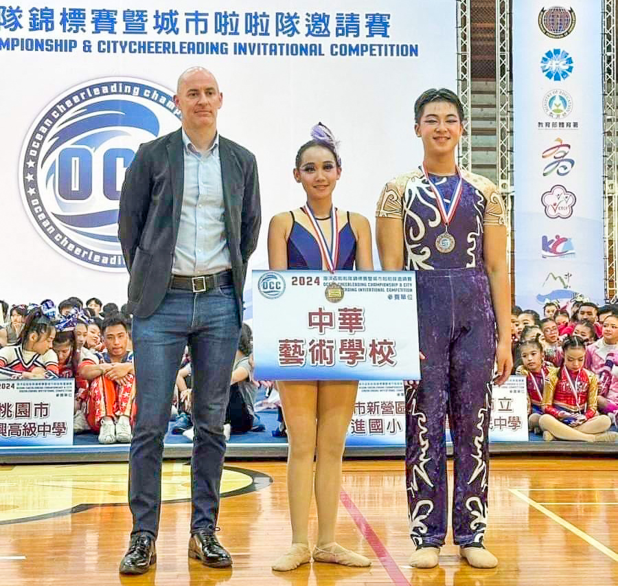 ▲日本啦啦隊協會(JCA)國際組執委、 國際總會國際組委員Mr.GRAVER Simon頒發高年級彩球雙人組第一名-中華藝校盧俊傑、李沅倢。（圖/中華藝校提供）