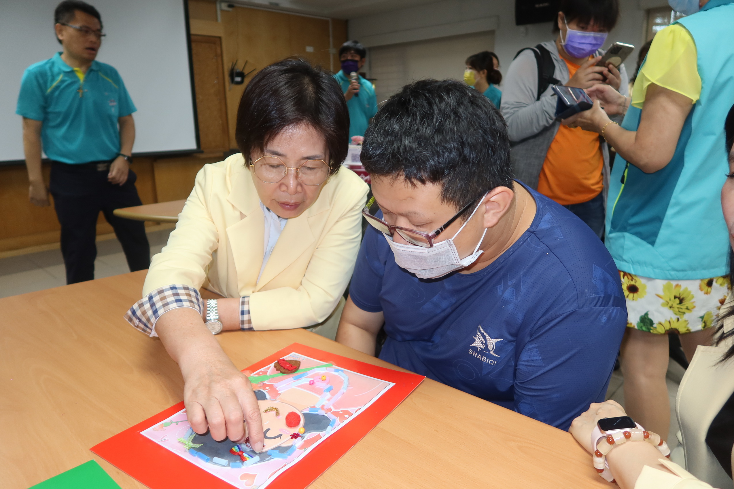 ▲彰化縣青溪婦女協會等社團募集經費用以協助彰化慈愛教養院的教室大樓重建工程，也與慈愛院生製作母親節卡片，以表達對教保老師的感激之情。（記者張溎壕攝）