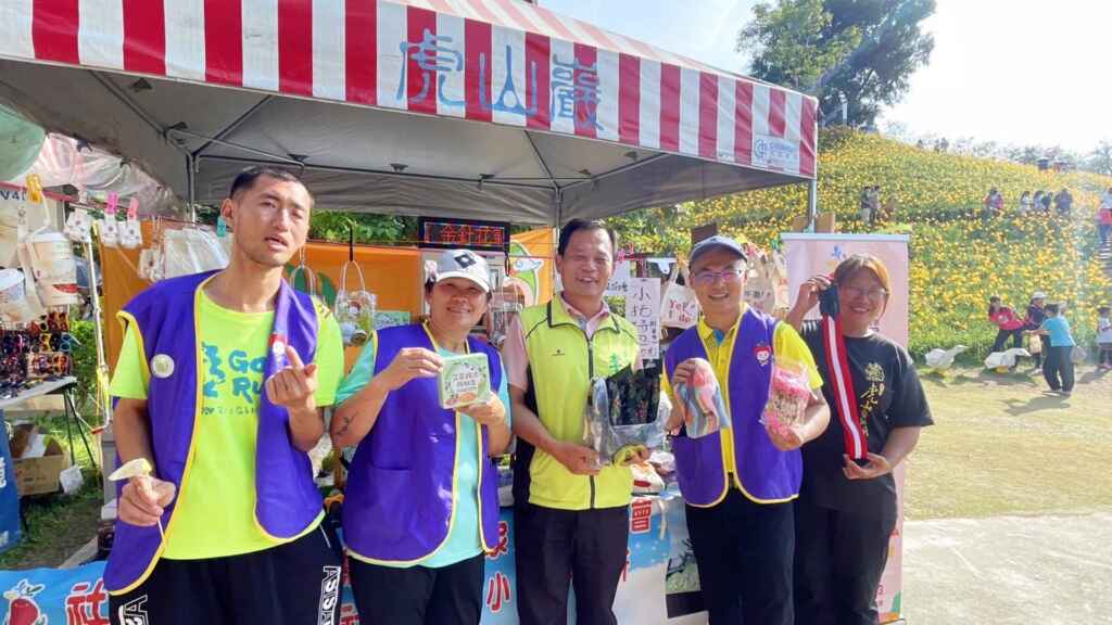 ▲彰化縣花壇鄉虎山巖金針花海大爆開,前往欣賞遊客絡繹不絕,園區周邊設有攤位市集,其中有社福團體設攤義賣,彰化縣議員李成濟 、花壇鄉民代表葉尚雯更到場協助叫賣。(記者林明佑翻攝)