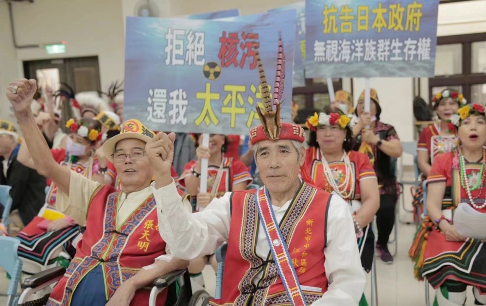 原住民高舉標語,希望日本當局重視核食及核污染廢水對海洋生態的破壞。 (圖/張天明提供)