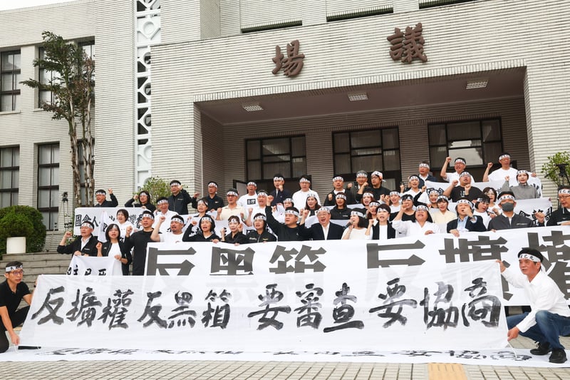 民進黨團在議場前拉起「反擴權 反黑箱 要審查 要協商」布條,抗議國民黨與民眾黨團破壞民主審查程序。中央社