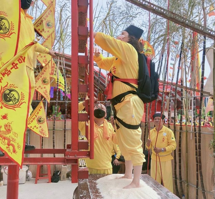 武當道教太玄法師協會主持蕭宴渝攀登刀梯。(圖/中國武當道教太玄法師協會)