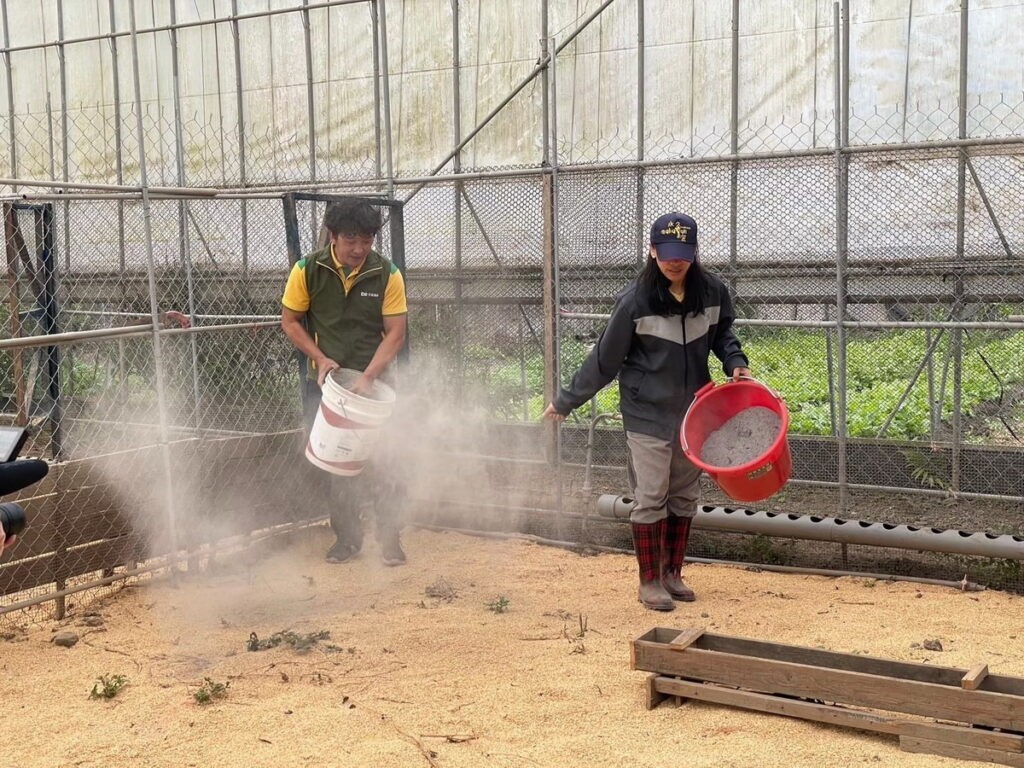 芥菜種會培育的第一座食農文化教育基地「三一食農久美據點」扎根南投,雞農烏瑪(右)整理雞舍,改善雞隻生活環境。(芥菜種會提供)