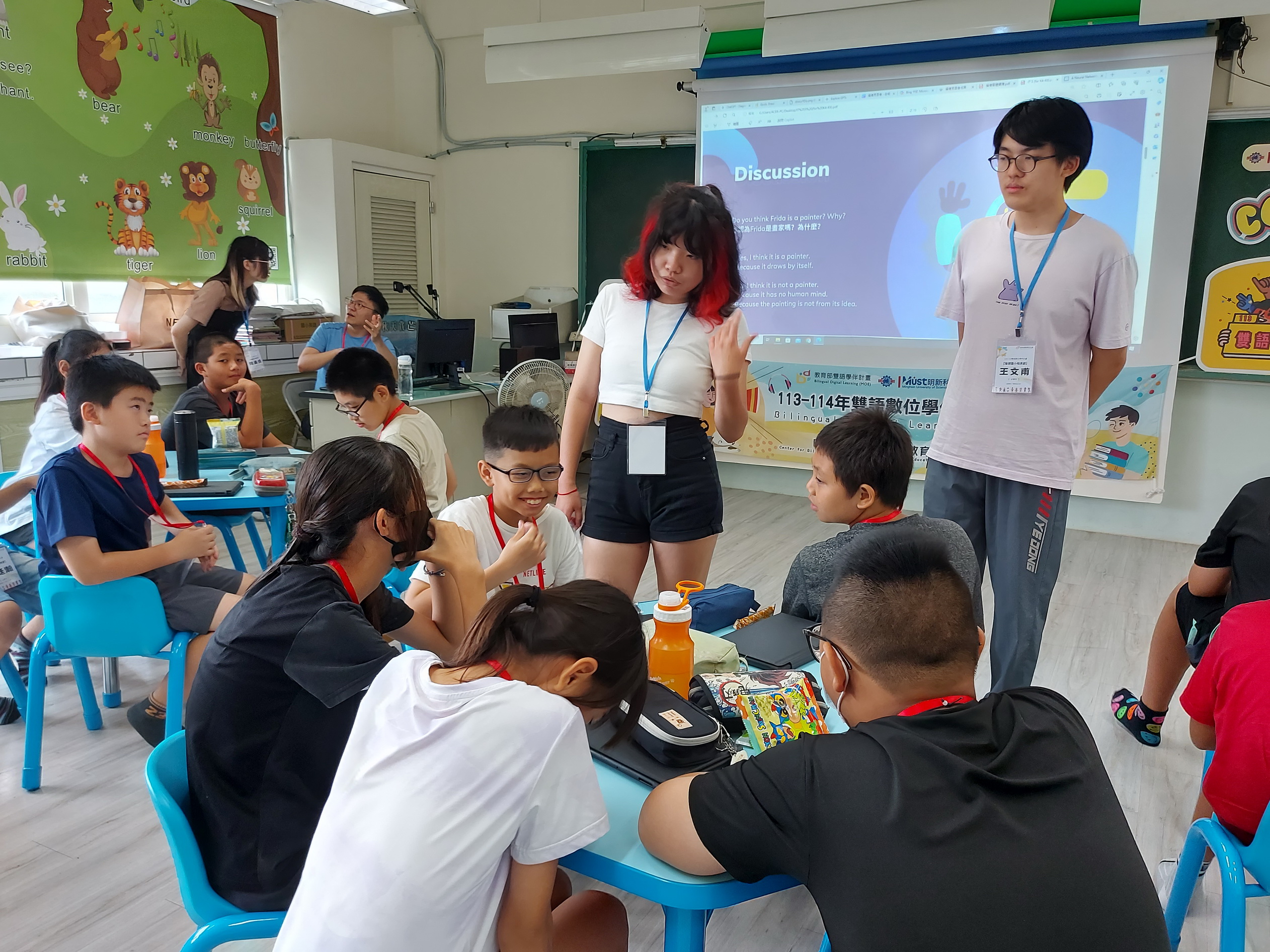▲大學伴許舒婷及吳有為透過雙語議題讓小學伴了解AI人工智慧及ChatGPT應用。（記者張溎壕攝）