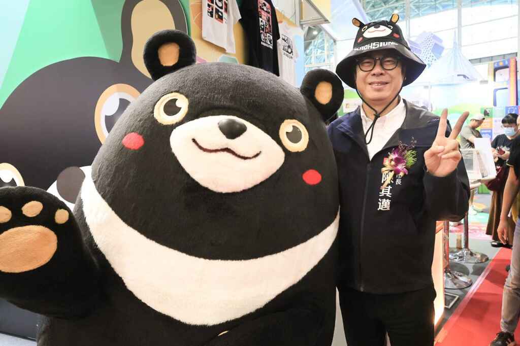 ▲高雄國際旅展高雄館以高雄觀光大使「高雄熊」為主軸,市長陳其邁頭戴高雄熊周邊帽子,化身最強推銷員,歡迎大家跟著高雄熊一同「大玩高雄」。(高雄市政府提供)