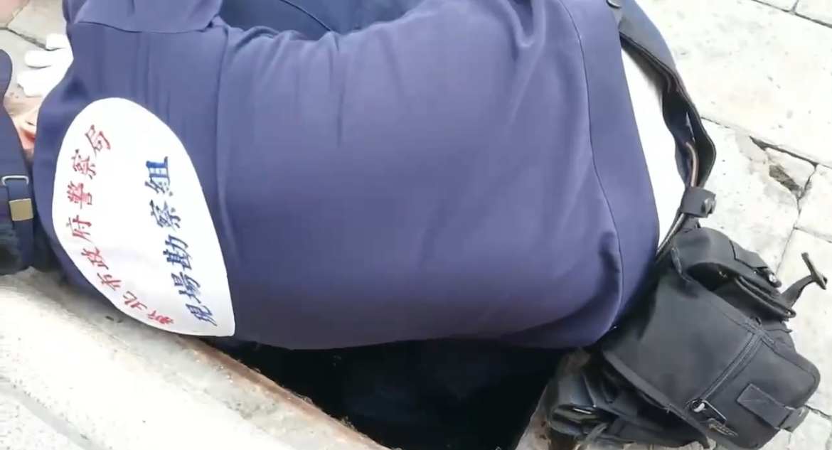 警方鑑識人員辛苦於臭水溝中挖找彈殼。(記者徐煜勝翻攝)