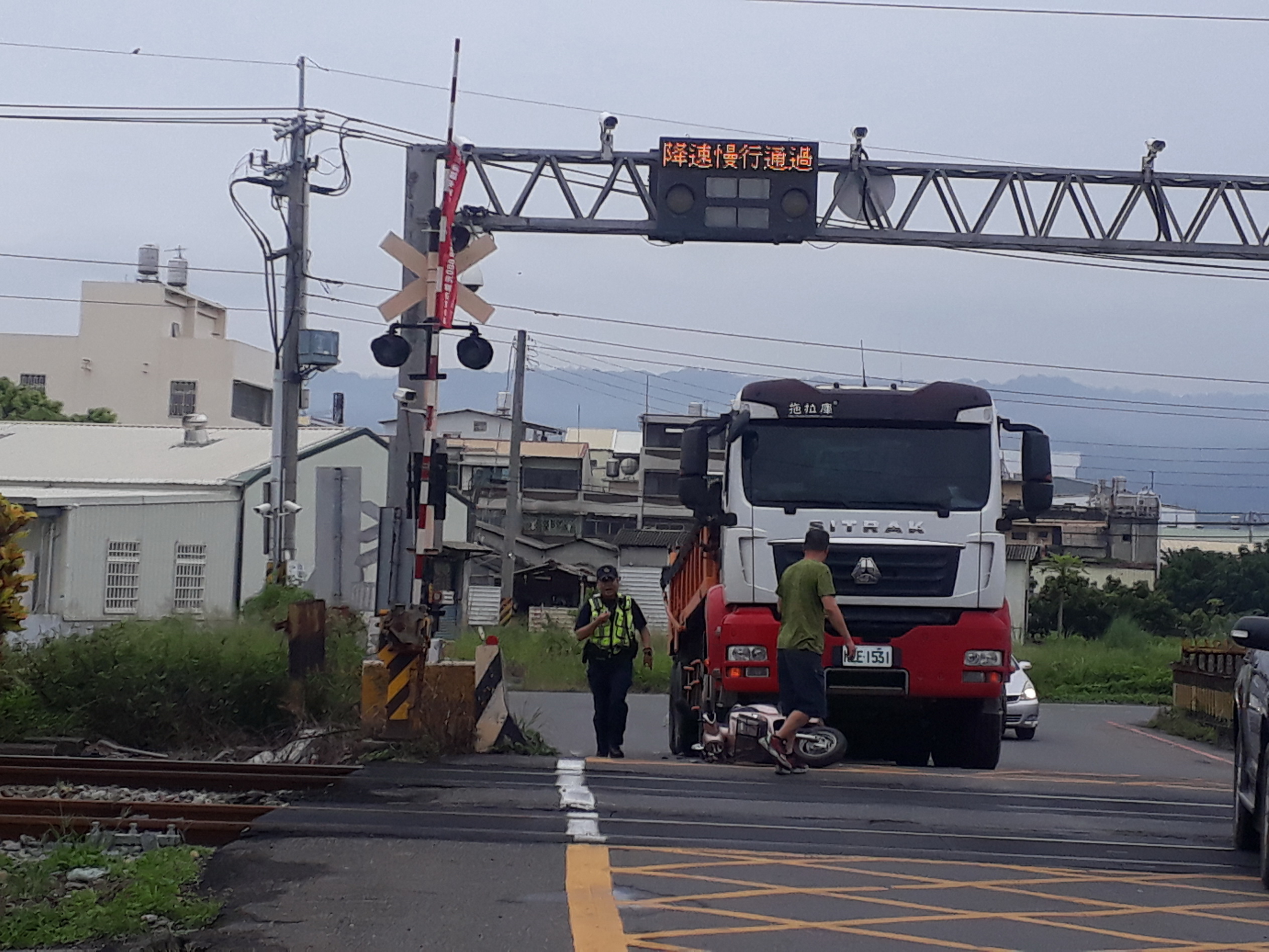 ▲社頭鄉社斗路鐵路平交道前發生一起砂石車與機車碰撞車禍，事故現場剛好在平交道柵欄前，當時列車已經駛過，騎士雙腿骨折送醫開刀。（記者張溎壕攝）