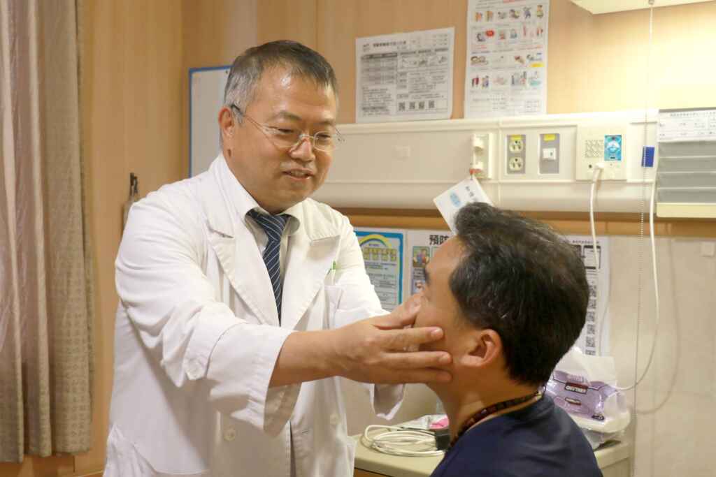 ▲廖光福主任觀察林先生的眼白泛黃程度。(台中慈濟醫院提供)