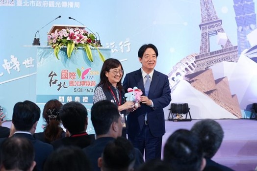 2024台北國際觀光博覽會5月31日登場,臺北市副市長林奕華出席開幕典禮,並贈送「2025雙北世界壯年運動會」吉祥物公仔-壯寶給總統賴清德,宣傳世壯運。 (臺北市政府觀光傳播局提供)