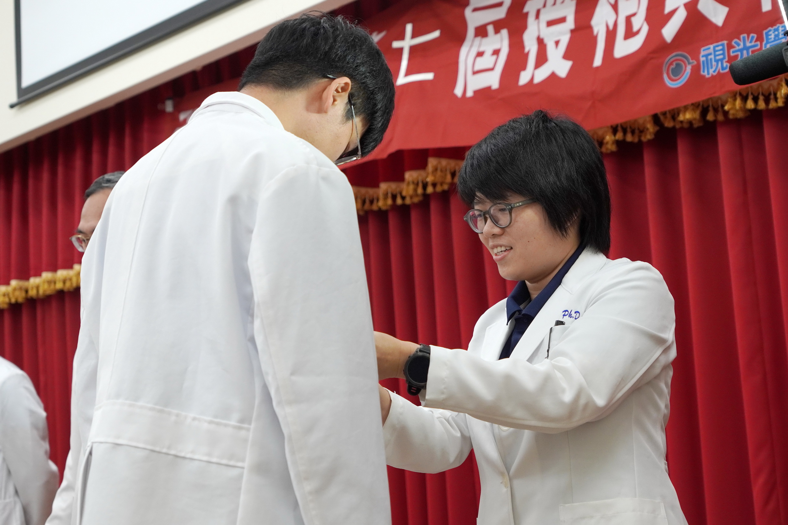 ▲大葉大學視光系老師為即將展開實習的學生穿白袍。（記者張溎壕攝）