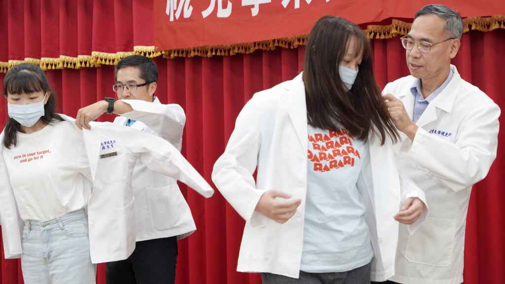 ▲大葉大學視光系授袍典禮,老師一一為學生穿上白袍。(大葉大學提供)