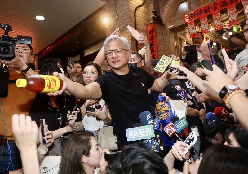 輝達(NVIDIA)執行長黃仁勳(中黑衣者)預計2日前往台大演講。圖為30日晚在台北與供應鏈廠商晚餐後,走出餐廳向守候媒體致意並大方請眾人喝飲料,展現親和力。圖/中央社