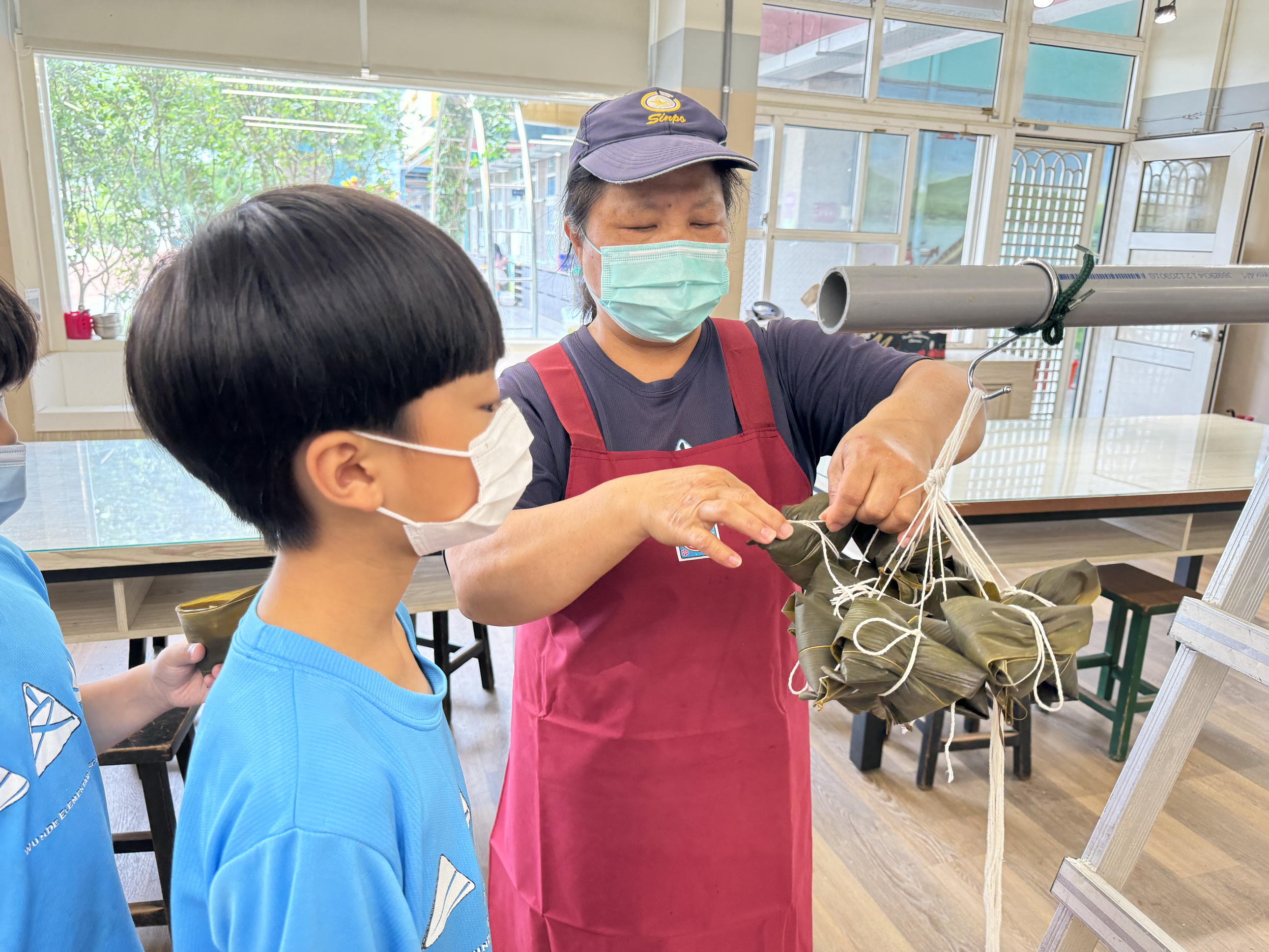 ▲芬園鄉文德國小安排來自菲律賓的外師及海外僑民兒童一起和學童動手學包肉粽。（記者張溎壕攝）