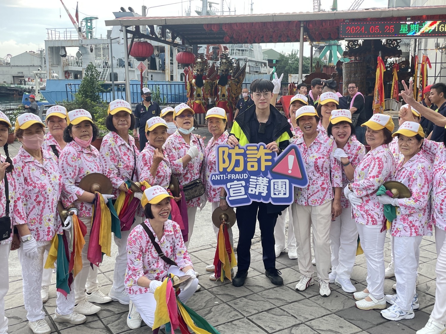 和一路派出所員警手持反詐標語向進香民眾進行反詐宣導。(記者薛秀蓮翻攝)