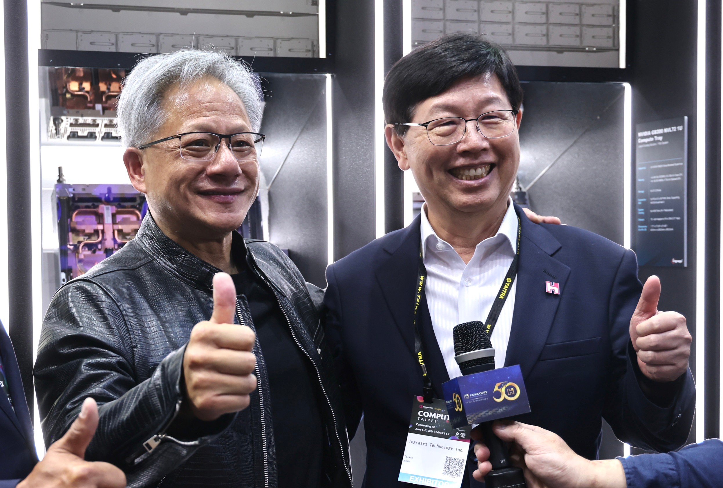 輝達(NVIDIA)執行長黃仁勳(左)4日在2024台北國際電腦展(COMPUTEX 2024)參訪鴻佰攤位,與鴻海董事長劉揚偉(右)互動、喊話。林啟弘攝