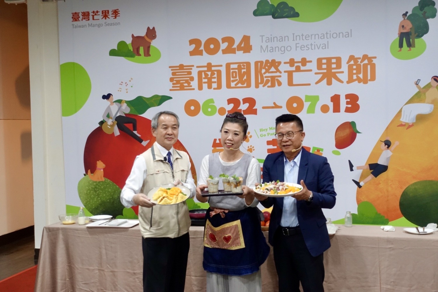 台南農業局局長李建裕(左)、阿芳老師蔡季芳 (中間)、農糧署副署長(右)於記者會上展示芒果創意料理。(圖/臺南市政府農業局 提供)