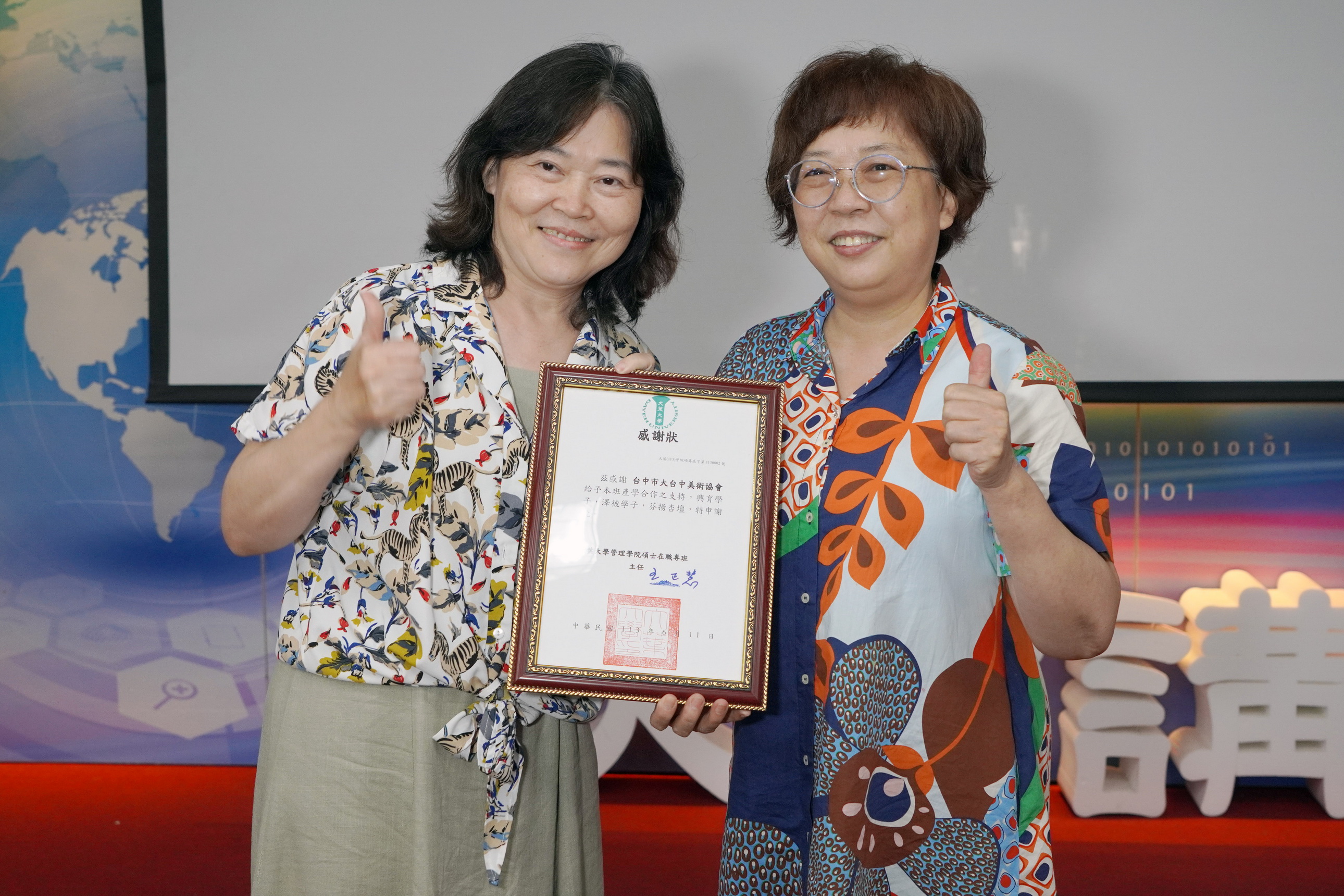 ▲大葉大學管理學院EMBA王正慧主任(左)致贈感謝狀給大台中美術協會理事長陳麗霓。（記者張溎壕攝）