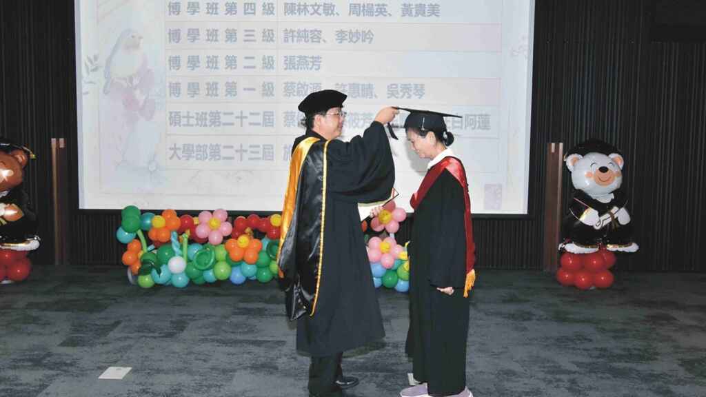 ▲松年大學總校校長阮介民牧師(左),為畢業生撥穗並予以祝福。(切膚之愛基金會提供)