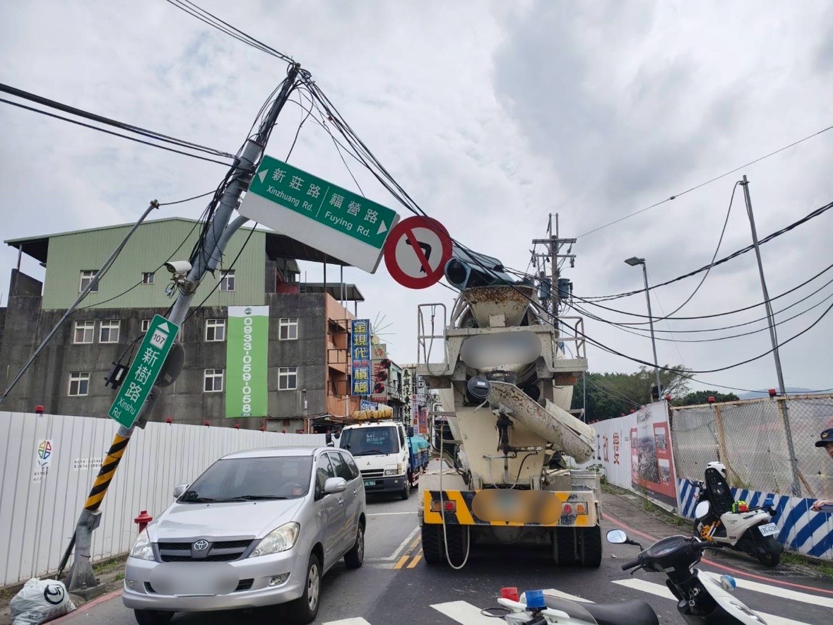 ▲新莊區新莊路與新樹路口，今（17）日傳出有水泥預拌車勾絆電線拉扯號誌桿倒製傾斜。（翻攝畫面）