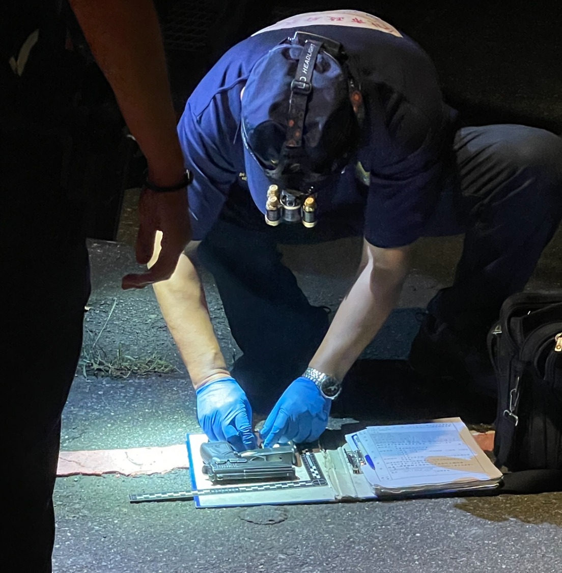 警方鑑識人員初驗槍枝。(記者徐煜勝攝)