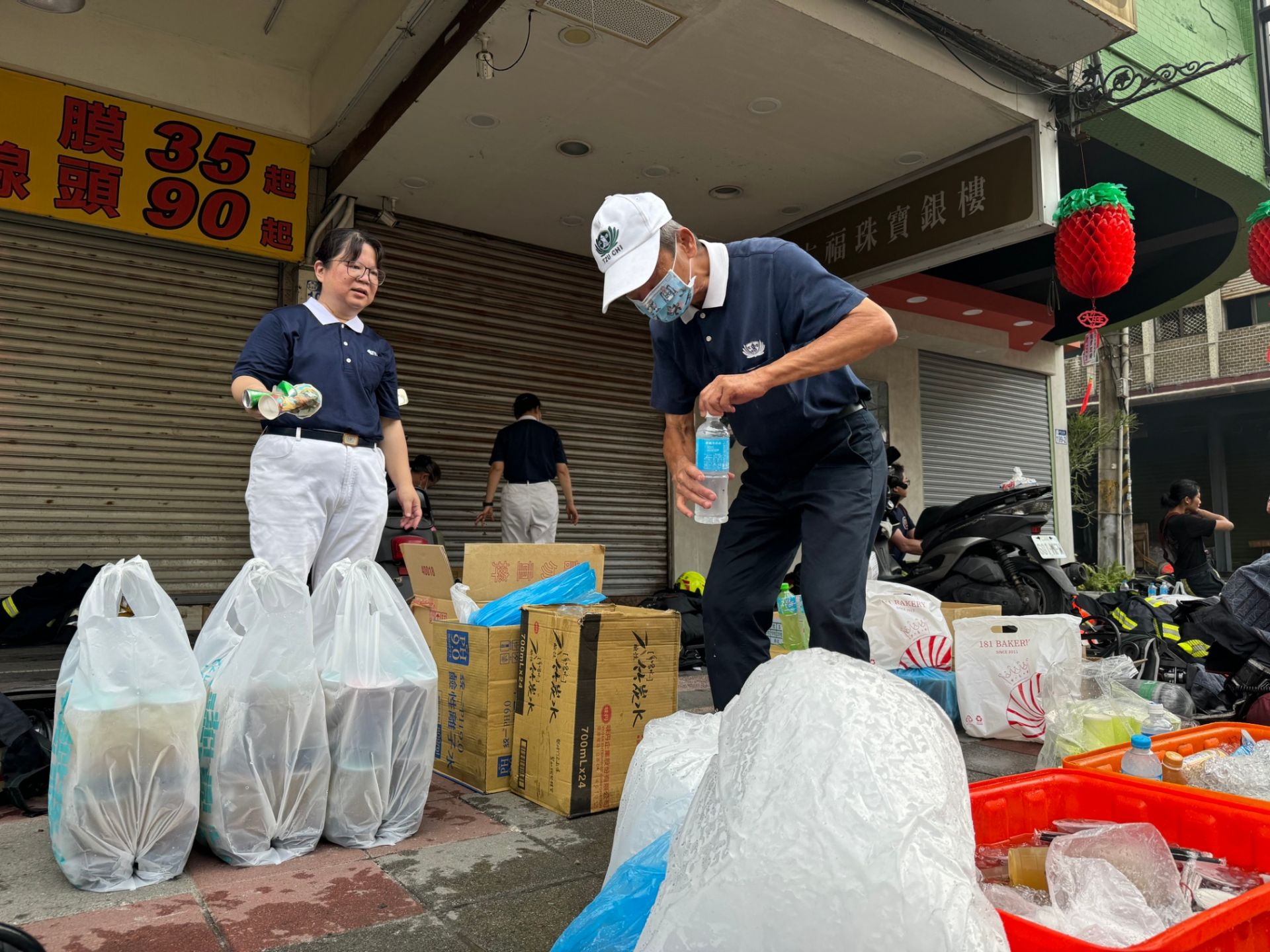 慈濟志工準備水、食物讓警消使用,並主動整理周圍環境,減輕消防人員整理工作。